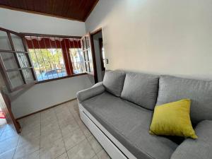 库奇拉阿尔塔Casa Alquiler Cuchilla Alta 2的客厅配有带黄色枕头的灰色沙发