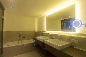 阿特湖畔翁特拉赫Hotel Stadler am Attersee的浴室设有2个水槽、浴缸和镜子