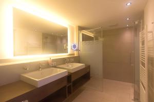 阿特湖畔翁特拉赫Hotel Stadler am Attersee的浴室设有2个水槽、镜子和淋浴。
