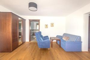阿特湖畔翁特拉赫Hotel Stadler am Attersee的客厅配有2把蓝色椅子和桌子