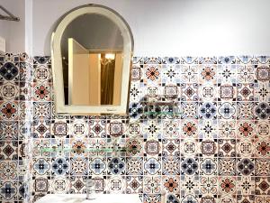 芹苴BÊ TÔNG RESIDENCES HOMESTAY的浴室设有瓷砖墙、镜子和水槽
