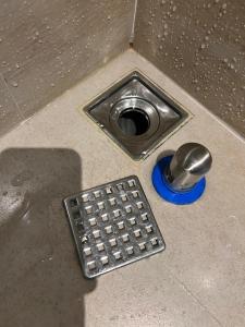 淡水欧朋仑旅店的金属狗碗和地面的排水管