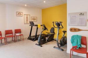 瑟堡DOMITYS LES SALINES的健身房,室内配有健身自行车和椅子