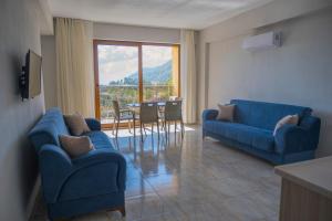 穆拉Olive Tree Apart Hotel的客厅配有2张蓝色的沙发和1张桌子