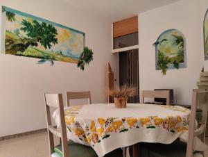 马鲁焦Villa d'Arte的一间设有桌子和墙上绘画的用餐室