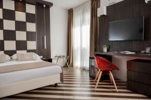 里乔内Dan Hotel的酒店客房配有一张床、一张桌子和一把椅子。
