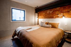 惠灵顿The Cobbler Hotel的一间卧室设有一张带砖墙的大床