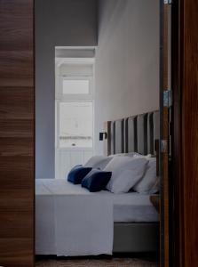 瓦莱塔Mulberry Suites的卧室配有带白色枕头的床和窗户。