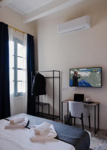 瓦莱塔Mulberry Suites的酒店客房设有一张床、一张书桌和一台电视机。