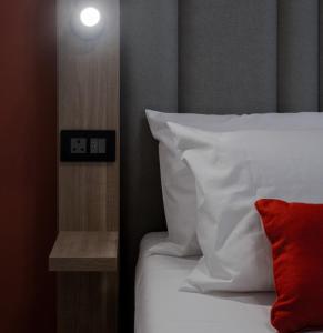 瓦莱塔Mulberry Suites的一张带白色床单和红色枕头的床