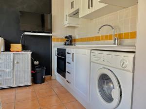 奥利瓦Par 3 Oliva Nova的厨房配有洗衣机和水槽