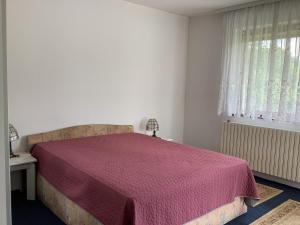 萨拉热窝Villa Nora Garden的一间卧室配有一张床铺,床上铺有红色毯子