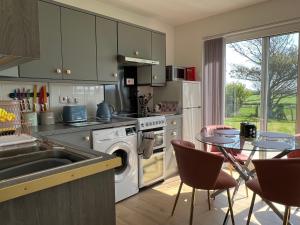 淡水VALLEY VIEW self-catering coastal bungalow in rural West Wight的厨房配有水槽和桌椅