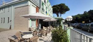 马里纳－迪拉文纳Hotel Maddalena的室外咖啡厅配有桌椅和遮阳伞