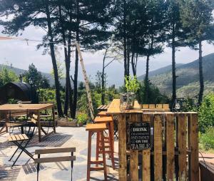 拉莫利纳Minds & Mountains Eco Lodge的庭院配有桌椅,享有山脉美景。