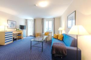 青斯特Aparthotel Zingst的客厅配有蓝色的沙发和书桌