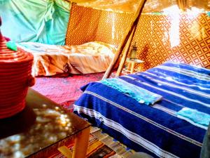 TissintAmoudou Lodge Camp的带帐篷、床和桌子的客房