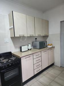 马塞卢Motebong Villa的厨房配有炉灶和微波炉。