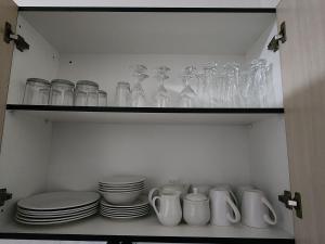 马塞卢Motebong Villa的装满玻璃杯、盘子和碗的架子