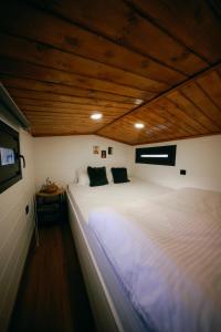 格雷梅Cappatiny House的一张白色大床,位于一个拥有木制天花板的房间