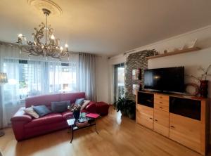 巴特利普施普灵格Erholungsapartment的客厅配有红色沙发和平面电视