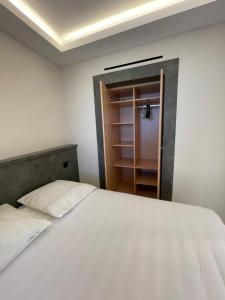 卢贝新城06AO - Superbe appartement avec vue mer exceptionnelle的卧室配有白色的床和衣柜。