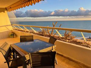 卢贝新城06AO - Superbe appartement avec vue mer exceptionnelle的俯瞰大海的阳台配有桌椅