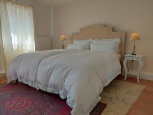马林诺维德Romantisches Ferienhaus in Moselnähe的卧室配有一张带白色床单和枕头的大床。