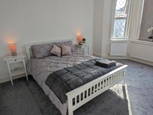 伯恩茅斯Cosy Bee的一间卧室配有白色床和2个床头柜