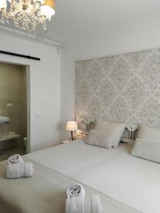 圣安东尼奥·德·卡隆Villa Costera B&B的卧室配有带毛巾的大型白色床