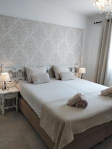 圣安东尼奥·德·卡隆Villa Costera B&B的一间卧室配有一张带两盏灯的大型白色床。