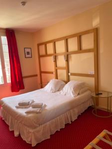 卢瓦尔河畔新堡Hôtel La Capitainerie的一间卧室配有一张大床和两条毛巾