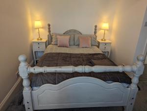 伯恩茅斯Cosy Bee的一间卧室配有一张带粉色枕头的床和两盏灯。