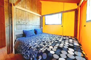 阿尔科巴萨Silver Coast Glamping luxury lodge的黄色间内一间卧室,配有一张床