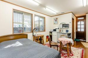 AsakayamachōSakai Kita-ku - House - Vacation STAY 10593的一间带一张床和一张书桌的卧室和一间厨房