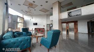 梅克内斯Hotel Jaouharat Ismaili的客厅配有2把蓝色椅子和桌子
