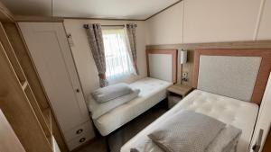 塔特舍尔Luxury Hotub Lodge with Lake View at Tattershall Lakes的小房间设有床和窗户