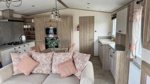 塔特舍尔Luxury Hotub Lodge with Lake View at Tattershall Lakes的客厅和厨房(大篷车内配有沙发)