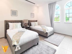 迪拜Luxury 3BR Private Villa and Elaborate Gardens的一间卧室设有两张床和窗户。