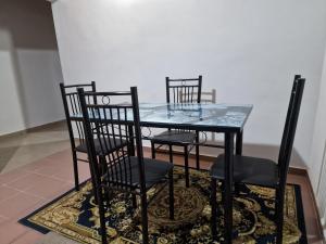NkongsambaLa Cité des Anges的地毯上的玻璃桌和四把椅子