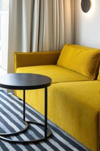 科沃布热格GreenPort Apartamenty Kołobrzeg - Dining & SPA的客厅配有黄色的沙发和桌子