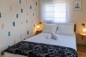 海法Domus Bat Galim Hotel的卧室配有黑色和白色的床以及白色枕头。