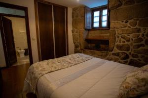 帕拉达Casa do Charco Peneda Gerês的一间卧室设有一张床和石墙