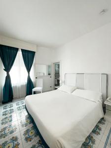 卡普里里贾纳克里斯蒂娜酒店的卧室配有白色大床和蓝色窗帘