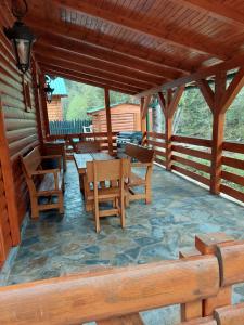 RožajeBrvnara Ibar的小屋的门廊配有木桌和椅子