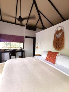 苏梅岛Jade cottages的卧室配有一张白色大床和一张书桌