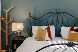 亨利昂泰晤士Henley Gardens的一间卧室配有一张带绿色床头板和枕头的床。