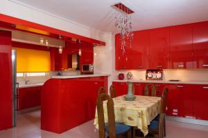 阿哈奈Glamour beautique villa的红色的厨房,配有桌子和红色橱柜