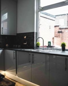 FarnworthComfortable Home In Bolton的带水槽的厨房台面和窗户