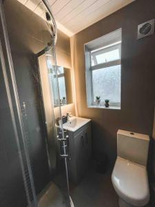 FarnworthComfortable Home In Bolton的带淋浴、卫生间和盥洗盆的浴室